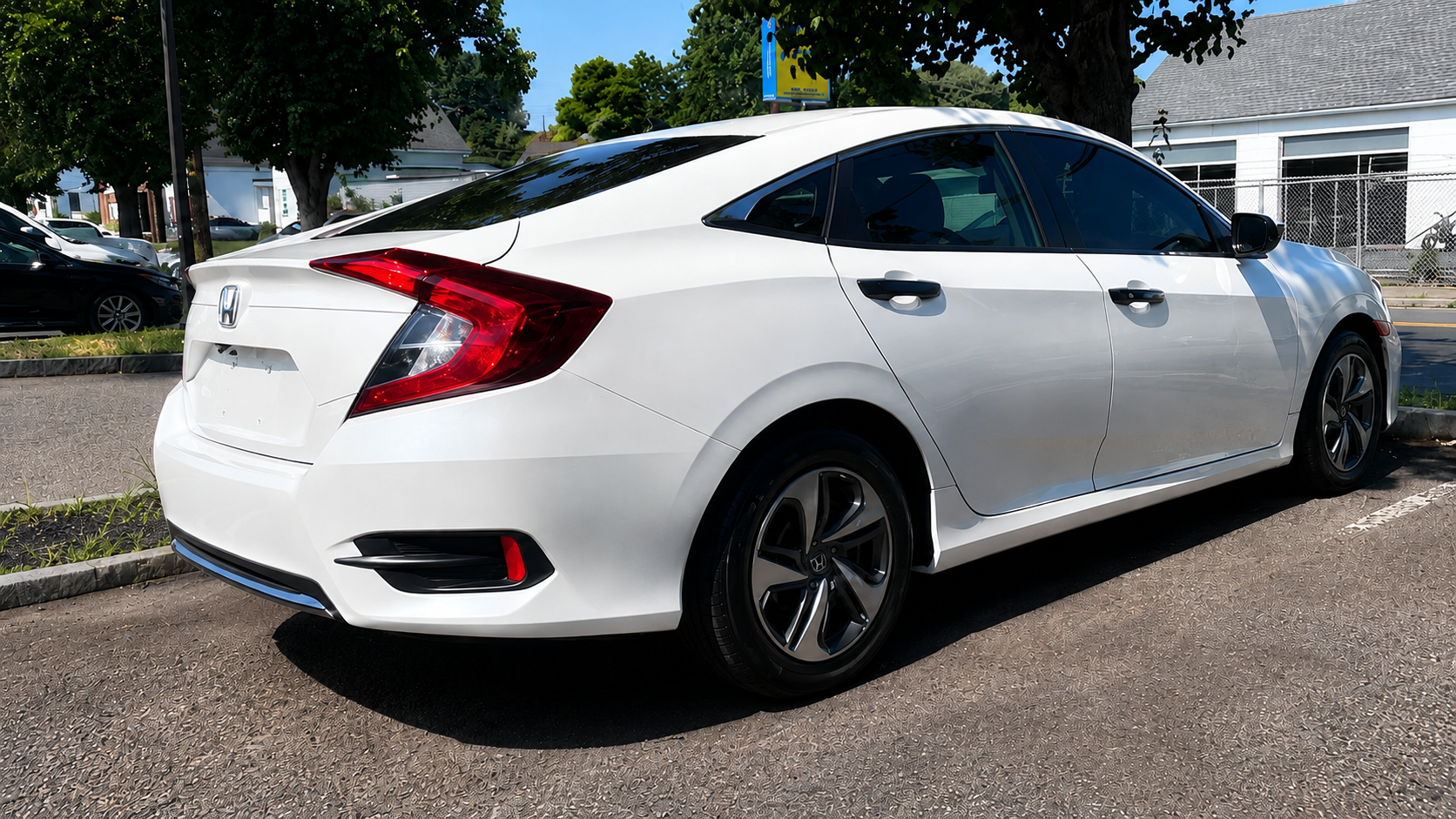 Completed rear-end auto body repair of a white Honda Civic with restored quarter panel, bumper and factory-matched white paint at WL Auto Collision in Brockton, Massachusetts.