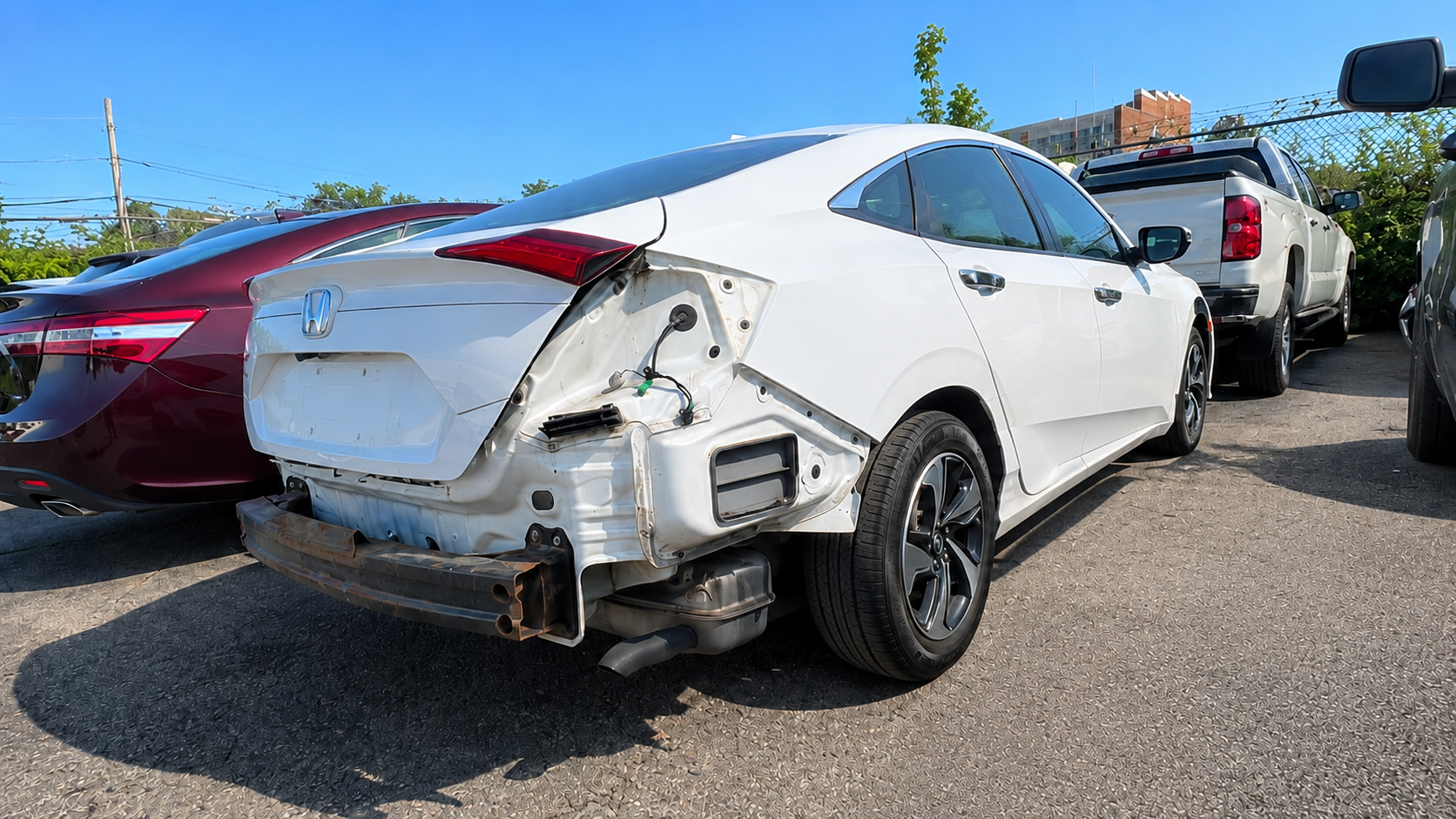 Before rear-end collision repair of a white Honda Civic showing damaged quarter panel and missing rear bumper at WL Auto Collision in Brockton, Massachusetts.