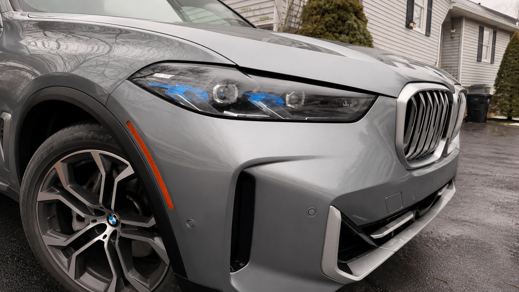 Completed front-left bumper and fender repair of a silver BMW X5 with restored panels and factory-matched paint at WL Auto Collision in Brockton, Massachusetts.