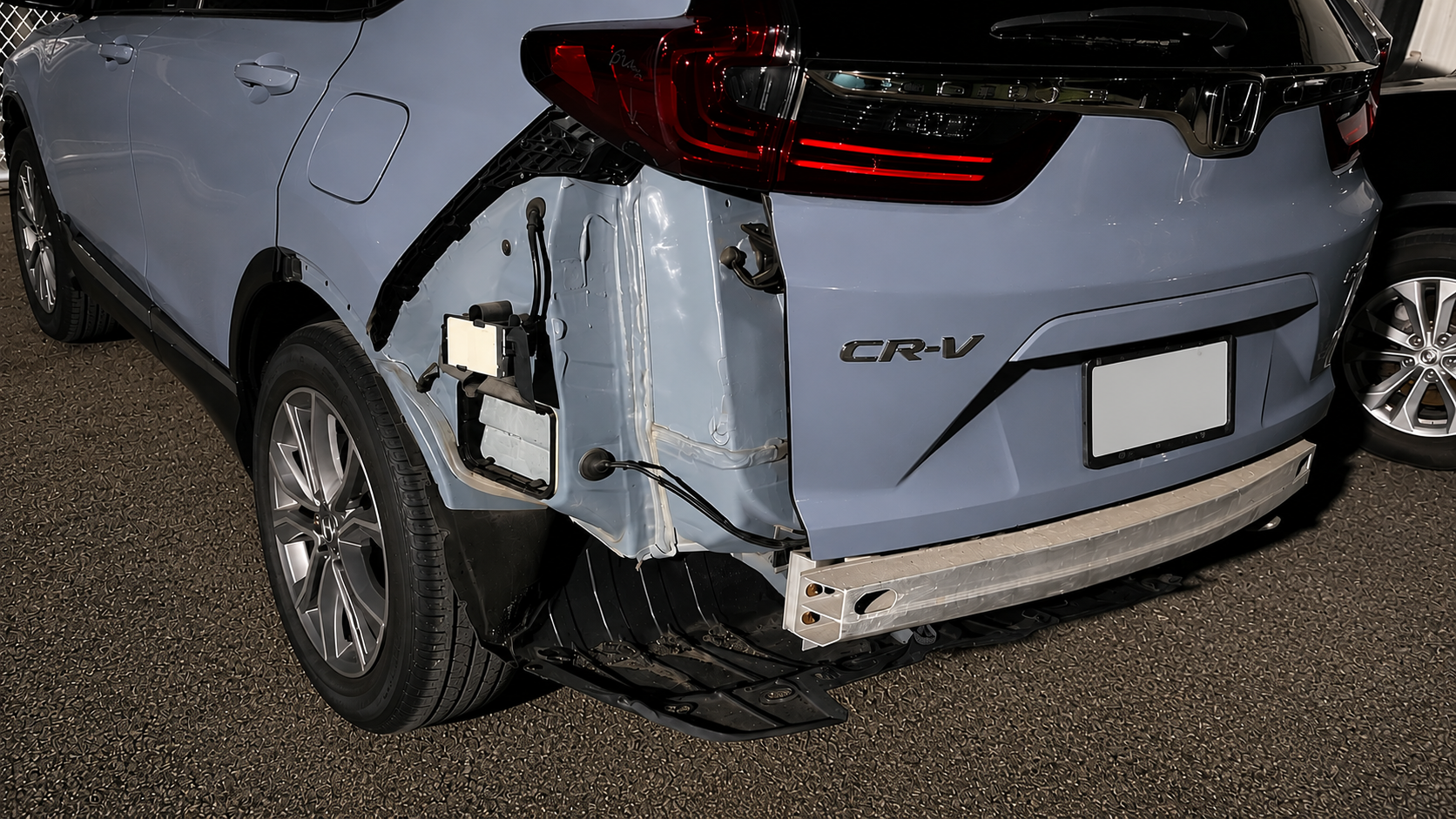 Before rear-end collision repair of a blue Honda CR-V showing crushed quarter panel, damaged tailgate and missing rear bumper at WL Auto Collision in Brockton, Massachusetts.
